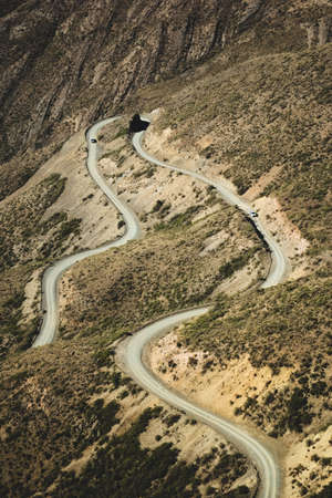 Narrow twisting dirt road across the Andes Mountains in Mendoza, Argentina.の写真素材