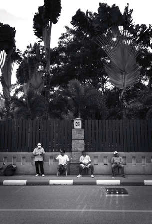 2019-11-05 / Phuket, Thailand - Four sitting men idling on the sidewalk. Black and white.のeditorial素材