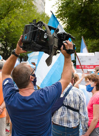 2021-02-27, Mendoza, Argentina - Cameraman holding a professional TV camera during a protest.のeditorial素材