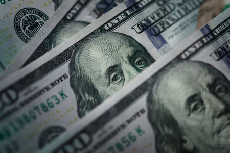 Several one hundred dolar bills. Extreme macro close up, focusing on the eyes of Benjamin Franklin.