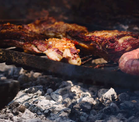 Roasted red meat over the grill in a traditional Argentinian asado. Close up detail.の写真素材