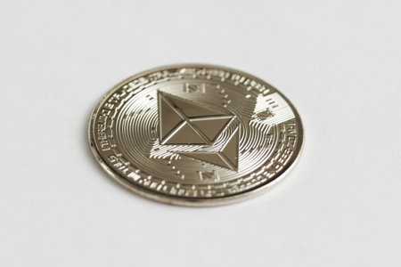 Silver physical Ethereum coin on white background. Digital currency, cryptocurrency, blockchain technology concept.の写真素材