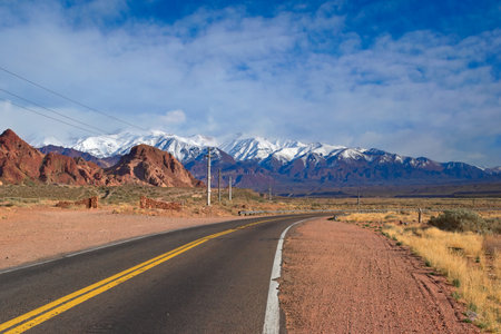 Asphalt road across the desert steppes by the Andes mountains near Uspallata, Argentina.の写真素材