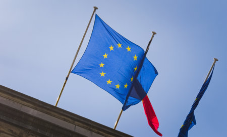 Flag of the European Union waving against the blue sky on a sunny day.の写真素材