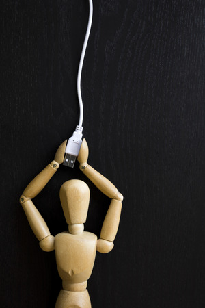 Wooden Figure Manikin Human Artist Draw Painting wood doll holding a usb connectorの写真素材