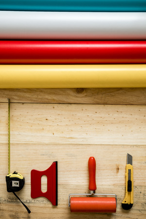 Colorful vinyl rolls on wooden background with your necessary instrumentsの写真素材