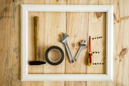 Old white frame Vintage with various tools forming the word love on wooden backgroundの写真素材