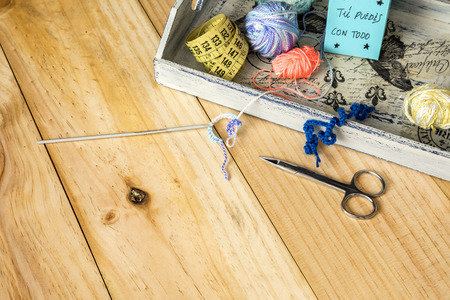 Box of tailor, scissor, tape measure and sewing threads with colorful bobbins for patchwork on...