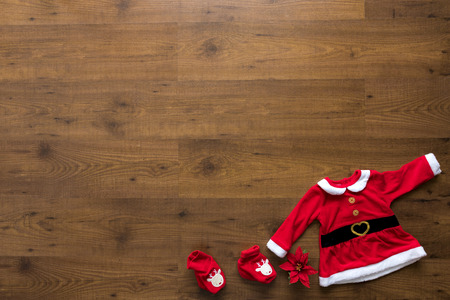 Christmas ornaments including poinsettia, sockers and christmas dress over wooden backgroundの写真素材