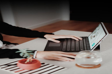 Businesswoman working on laptop at home. Female hands typing on keyboard.の写真素材