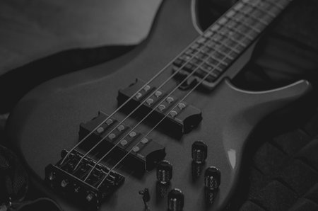 Electric guitar on a dark background. Close-up. Black and white photo.