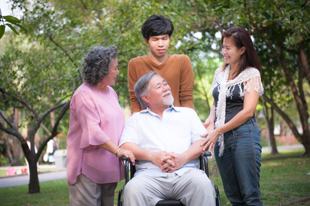 cheerful disabled grandfather in wheelchair welcoming his happy Family.の写真素材