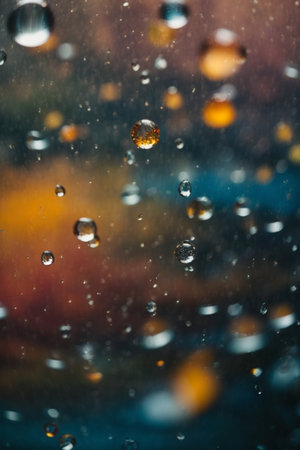 raindrops on glass with bokeh background, shallow depth of fieldの素材