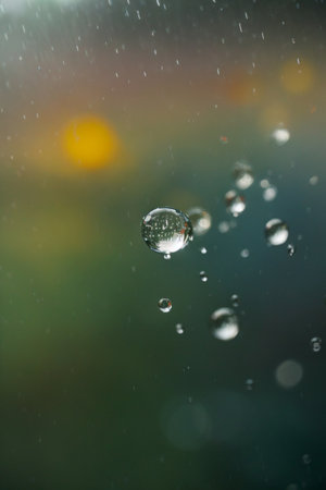 Water drops on glass with nature bokeh background, stock photoの素材
