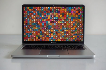 Laptop with colorful apps on the screen on a white background.の素材
