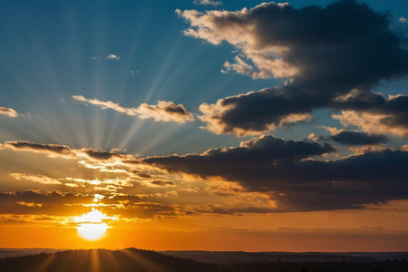 Sunset over the mountains with clouds and rays of light in the skyの素材