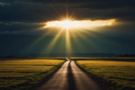 Sunset over a country road with the sun passing through the cloudsの素材