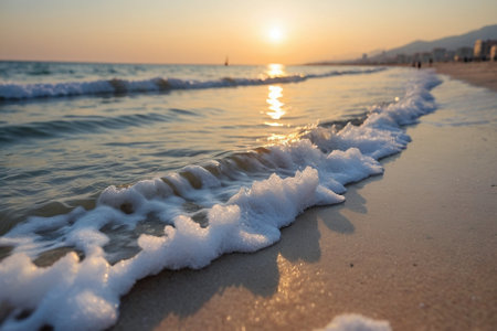 Sunset on the beach with waves and foam in the foreground.の素材