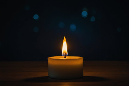 Burning candle on a wooden table with bokeh background.の素材