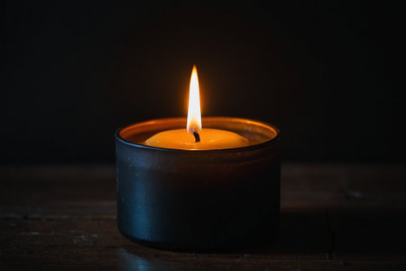 Candle on a wooden table in a dark room with copy spaceの素材