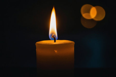 Burning candle on a black background, close-up, selective focusの素材