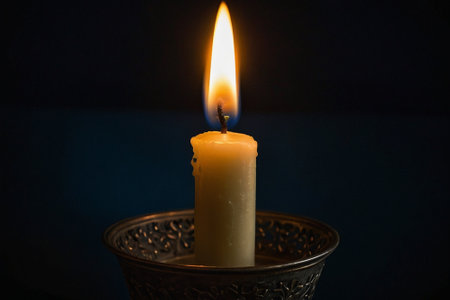Candle lit in a vase on a dark background close upの素材