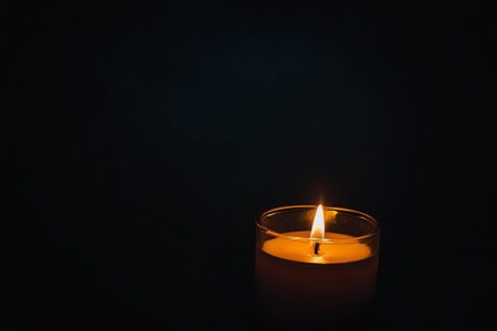 Burning candle on dark background, close up. Space for textの素材