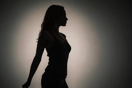Silhouette of a beautiful young woman posing in the studio.の素材