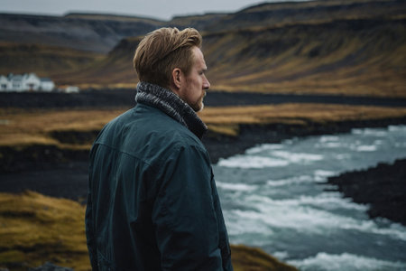 Handsome young man standing in front of a mountain river, Icelandの素材