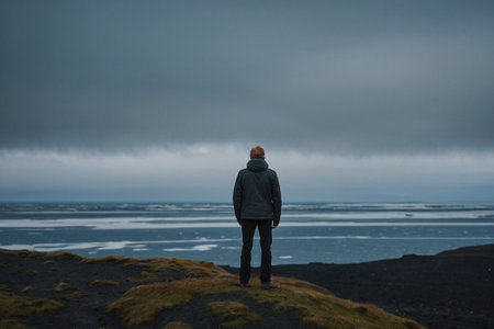 Man standing on the edge of a cliff, Iceland, Europe.の素材