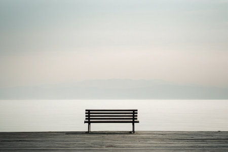 Wooden bench in the middle of the sea with mountain background.の素材