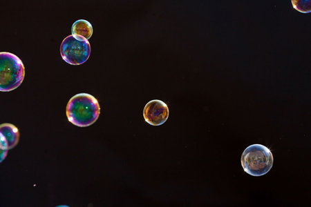 Soap bubbles with reflection on black background. Shallow depth of field.の写真素材