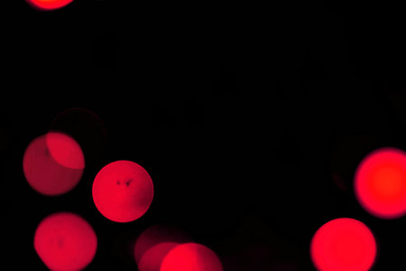 Abstract circular bokeh background of Christmaslight. Red and blackの写真素材