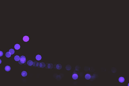 Purple bokeh on black background with copy space for text