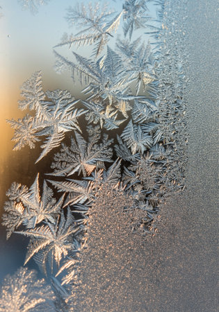 Frosty natural pattern on winter window glass as an abstract backgroundの写真素材