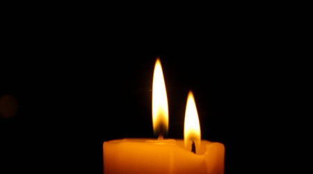 Burning candle on a black background, close-up of candlesの写真素材