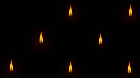 Seamless pattern of burning candles on a black background. The concept of faith and hope.の写真素材
