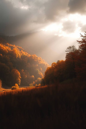 Autumn landscape in the mountains with sunbeams through the cloudsの写真素材