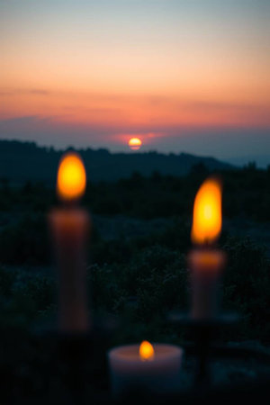 Candle light in the garden with beautiful sunset background. Selective focus.の写真素材