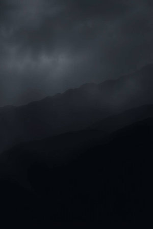 Dark stormy sky with dark clouds over a mountain range. Abstract background.の写真素材