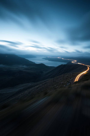 A long exposure shot of a road in the mountains with motion blurred