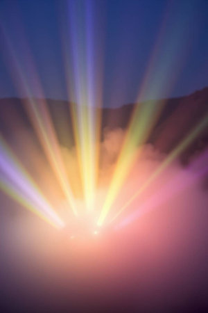 Colorful rays of light on a foggy morning in the mountainsの写真素材