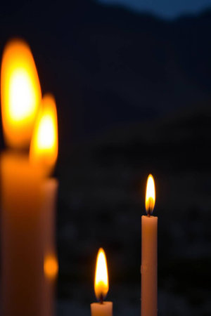 Candles lit in the dark with a background of mountains in the backgroundの写真素材