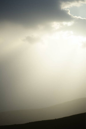 Clouds in the sky with sunbeams and rays of lightの写真素材