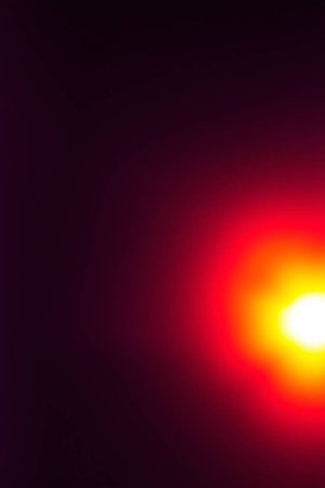 Sunset with lens flare. Colorful light flares. Glowing streaks on dark background. Luminous abstract sparkling lined background. Space for text.の写真素材