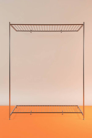 Empty metal rack on orange and white background with copy space for text