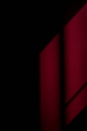 abstract red and black background with diagonal stripes and shadow on the wallの写真素材