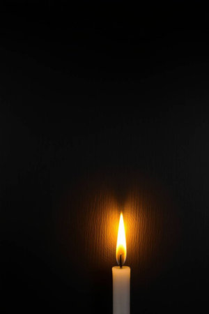 Burning candle on a black background.の写真素材