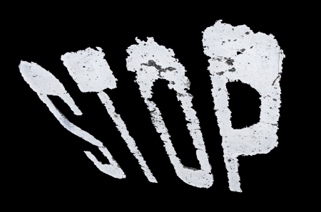 Stop sign painted on the wall isolated over black background