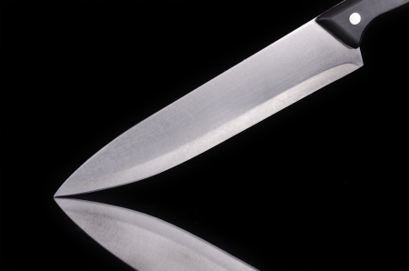 Close up view of a kitchen knife over black isolated backgroundの写真素材